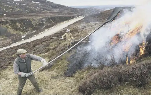  ??  ?? Controlled burning by Dunmaglass Estate head keeper Iain Hepburn, left, and Station Officer Alex Mckinley, of the Scottish Fire Service