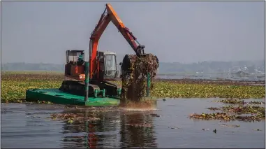  ?? ?? A de-weeding machine removes weeds and lotus lilies Sept. 14 at Dal Lake.