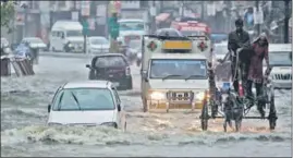  ?? AP ?? A man riding his cart through a flooded street during heavy rainfall in Jammu on Wednesday.