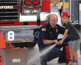  ?? PHOTOS BY MARIAN DENNIS — DIGITAL FIRST MEDIA ?? Kids got a chance to put out a fire Wednesday during one of the demonstrat­ions going on at Royersford Emergency Services Night.