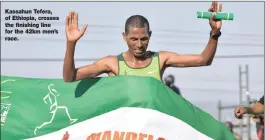  ??  ?? Kassahun Tefera, of Ethiopia, crosses the finishing line for the 42km men’s race.