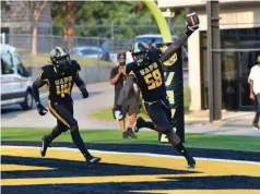  ?? (Special to The Commercial/ Darlene Roberts) ?? Defensive end Kailon Davis holds the ball high as he sweeps through the end zone
Saturday night. Trailing him is Monroe Beard III, a linebacker.