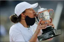  ?? ASSOCIATED PRESS FILE PHOTO ?? Poland’s Iga Swiatek kisses the trophy after winning the final match of the 2020French Open against Sofia Kenin of the U.S. in two sets, 6-4, 6-1, at the Roland Garros stadium in Paris.