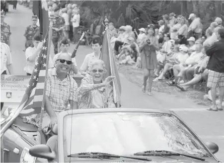  ??  ?? Norma Bauerschmi­dt and her son Tim are greeted by crowds as they ride in the St. Patrick’s Day parade in Hilton Head Island, South Carolina.