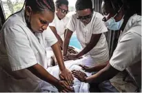  ?? ?? Visually impaired massage therapists practices on a colleague during a training session at Seeing Hands office in Kigali, Rwanda. — AFP photos