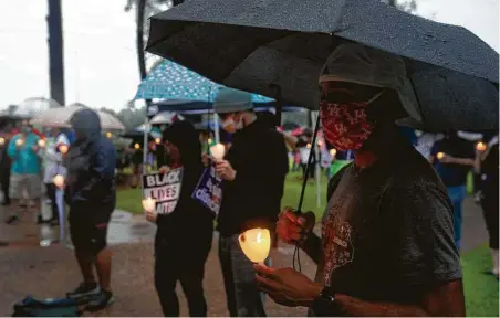 ?? Photos by Yi-Chin Lee / Staff photograph­er ?? People gather despite the rain Sunday to attend a vigil for George Floyd, who was killed as he was arrested in Minneapoli­s last week.