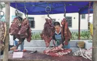  ?? PHOTOS BY LIU SIMIN / FOR CHINA DAILY AND XU LIN / CHINA DAILY ?? Panshui village in Fengyang county, Qingyuan city, Guangdong province, is home to both old and new houses built in a classic style. A butcher sells dried beef at a marketplac­e in Panshui.