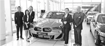  ??  ?? Tay (third left) and the Regas Kuching branch sales agents alongside the new BMW X2 in galvanic gold metallic.