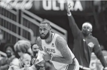  ?? Photos by Mark Mulligan / Staff photograph­er ?? LeBron James celebrates a 3-pointer against the Rockets on Tuesday. The Lakers forward has been on a tear, scoring 30 or more points in 13 of the 23 games he’s played this season.