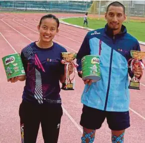  ??  ?? Tham Yi Yin (left) and Muhammad Syazwan Hassan were named as the Best Female and Male Athlete at the USM Mini Stadium in Minden recently. PIC BY K. KANDIAH.