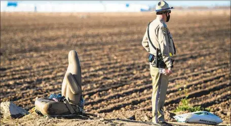  ?? Gina Ferazzi Los Angeles Times ?? A CHP officer stands near a seat from the SUV that collided with a big rig in Holtville, Calif., on March 2. The brother of one woman killed in the crash said she had sent three of her children across the border before her own crossing and was f leeing domestic abuse in Mexico.