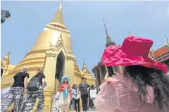 ?? WICHAN CHAROENKIA­TPAKUL ?? Tourists visit the Temple of the Emerald Buddha and the Grand Palace. Officials are maintainin­g their target of 38 million foreign visitors this year.