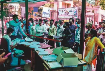  ?? AP ?? A hospital staff tries to pacify an impatient crowd during the registrati­on process for getting tested for Covid-19 at a government hospital in Noida, a suburb of New Delhi, yesterday.