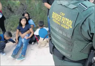  ?? John Moore Getty Images ?? ASYLUM SEEKERS wait as U.S. Border Patrol agents take them into custody in Texas on June 12.