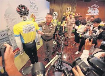  ?? PHRAKRIT JUNTAWONG ?? This T-shirt designed by His Majesty the King shows a family of cartoon characters cycling together on the back of the garment, which will be worn by participan­ts in the ‘Bike Un Ai Rak’ event on Dec 9.