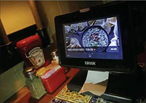  ?? ELISE AMENDOLA — THE ASSOCIATED PRESS ?? A Ziosk tablet displays an appetizer a customer can order at a Chili’s restaurant in Andover, Mass.