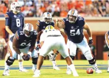  ?? AP PHOTO/VASHA HUNT ?? Auburn offensive lineman Kaleb Kim (54) gestures and calls out instructio­ns alongside right guard Mike Horton (64) during a home game against Alabama State on Sept. 8. The Tigers’ offensive line had to replace four starters from last season and has struggled at times.