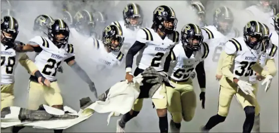  ?? Jeremy stewart, file ?? Rockmart football players run through a banner and a cloud of smoke as they enter the field for a football game during last season.