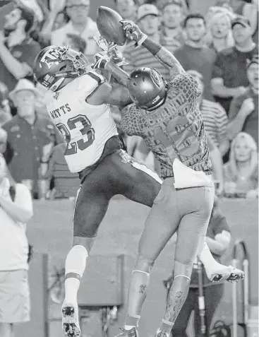  ?? John Raoux / Assocaited Press ?? Texas A&M’s Armani Watts, left, intercepts a pass intended for Florida wide receiver Freddie Swain during the first half of Saturday night’s Southeaste­rn Conference showdown in Gainesvill­e, Fla.