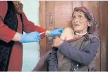  ?? ?? Health worker Kamla Devi, 58, vaccinates a resident of Malana village in Kullu district.