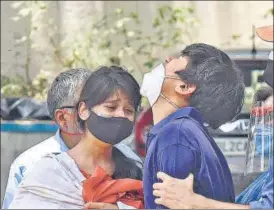  ??  ?? Relatives of a Covid-19 victim outside a mortuary on Sunday.