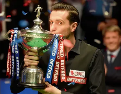  ?? AFP ?? England’s Mark Selby kisses the trophy after beating Scotland’s John Higgins in the World Championsh­ip Snooker final. —