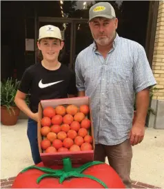  ?? (Special to The Commercial/University of Arkansas System Division of Agricultur­e/John Gavin) ?? River Grice (left), a fifth-generation farmer in Warren, brought in the first box of tomatoes for 2021 to the Bradley County Cooperativ­e Extension Service office. River is pictured with his father, Lynn Grice.