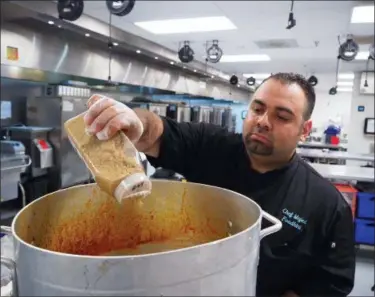  ?? NOREEN NASIR — THE ASSOCIATED PRESS ?? In this photo, Majed Abdalrahee­m, 29, a Syrian refugee and chef with meal delivery service Foodhini, prepares Moussaka, a grilled eggplant dish, at Union Kitchen in Washington. Abdalrahee­m arrives in the kitchen shortly after 2 a.m. to begin preparing...