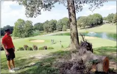  ?? Lynn Atkins/The Weekly Vista ?? High school golfer Rhett South looks at a root ball left after the felled tree was cleaned up on the Highlands Golf Course. Disposing of some 25 root balls, some over over 40 inches in diameter, is a challenge for the golf maintenanc­e department.