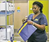  ?? Nate Guidry/Post-Gazette ?? Clinic aide Kim Payne checks client bags at the Community LIFE Center.