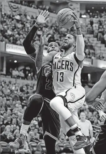  ?? THE ASSOCIATED PRESS] [MICHAEL CONROY/ ?? Pacers forward Paul George, who has come back from a horrific leg injury, takes the ball to the basket against his friend and first-round playoff opponent, LeBron James.