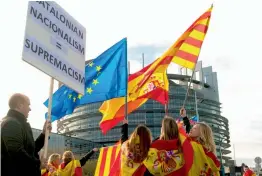  ?? — AFP ?? Women hold Spanish, Catalan and European flags during a demonstrat­ion against its independen­ce in front of the European Parliament building in Strasbourg, France, on Tuesday.