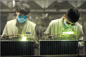  ?? AP/ MARK SCHIEFELBE­IN ?? Factory workers use torches to complete air- conditioni­ng condenser units on an assembly line at a Haier factory in Jiaozhou near Qingdao in eastern China’s Shangdong province.