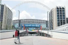  ?? REUTERS ?? People wearing face masks walk outside Wembley.