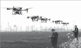  ?? HU WEIGUO / FOR CHINA DAILY ?? Growers get training to use unmanned aerial vehicles to protect crops in Mengcheng county, Anhui province, in March.