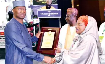  ??  ?? Secretary to Government of the Federation, Boss Mustspha (left) presenting an award to Minister of State, FCT, Dr. Ramatu Tijjani Aliyu for her appointmen­t as minister during a programme organised by ABU alumni at Abuja