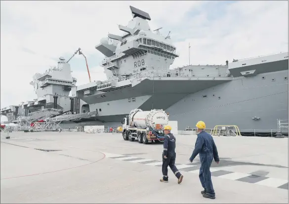  ??  ?? DERELICTIO­N OF DUTY: The new aircraft carrier HMS Queen Elizabeth prepares to be put to sea for trials. But the state of Britain’s Armed Forces reflects years of erosion of our military capacity.