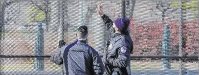  ?? John Minchillo The Associated Press ?? Capitol Police officers look at fencing that was installed Thursday around the exterior of the Capitol grounds.