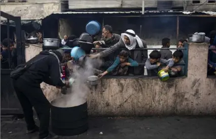  ?? Fatima Shbair/Associated Press ?? Palestinia­ns line up for food Friday in Rafah, Gaza Strip. Internatio­nal aid agencies say Gaza is suffering from shortages of food, medicine and other basic supplies as a result of the war between Israel and Hamas.