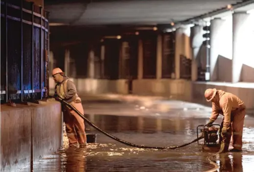  ?? ASHLEE REZIN GARCIA/SUN-TIMES ?? City workers remove water from Lower Wacker Drive near Randolph Street in May after overnight flooding from heavy rain.