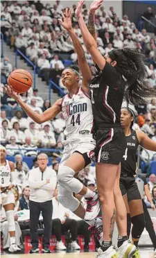  ?? Tyler Sizemore/Hearst Connecticu­t Media ?? UConn guard Aubrey Griffin, left, makes a layup over South Carolina forward Kamilla Cardoso on Sunday.