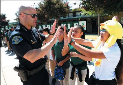  ?? ARIC CRABB — STAFF PHOTOGRAPH­ER ?? San Jose Police Chief Eddie Garcia high fives students during a visit to Arbuckle Elementary School in San Jose on Monday.