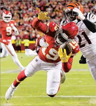  ?? Brynn Anderson Associated Press ?? CHIEFS RECEIVER Kadarius Toney tries to control a pass in front of Bengals cornerback Mike Hilton in the first quarter. The pass was ruled incomplete and upheld after a Chiefs challenge.