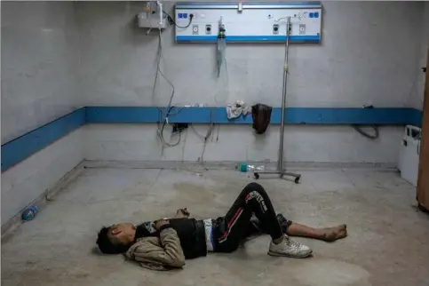  ?? ?? Al-Shifa opererer på staerkt nedsat kapacitet. Her ses en ung mand ligge på gulvet i en stue, mens han venter på behandling. Billedet er fra fredag den 15. marts. Foto: AFP