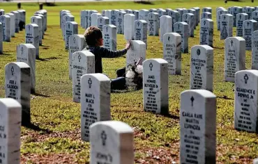  ?? Photos by Kin Man Hui / Staff photograph­er ?? Denise Cobb, above, caresses the headstone of her late husband, Air Force Col. Jerry Cobb, at Fort Sam Houston National Cemetery on Wednesday. Cobb joined other families who spent Veterans Day paying respects to loved ones. Cobb said she wanted to honor her husband’s sacrifice and celebrate the lives of all veterans.