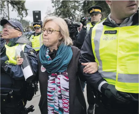  ??  ?? Federal Green Party Leader Elizabeth May is arrested by RCMP officers after joining protesters outside Kinder Morgan’s facility in Burnaby on Friday. “I feel in my heart that I’ve done the right thing,” May says. More photos, A4