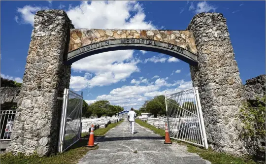  ?? PHOTOS BY MARTA LAVANDIER/AP ?? Jessie Wooden, owner of the Lincoln Memorial Park Cemetery, walks through the front gate Feb. 26 in the Brownsvill­e neighborho­od of Miami. After Wooden serendipit­ously learned about his mother’s resting place, he tried to visit but found the vast graveyard overgrown, snake-infested and surrounded by debris.