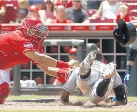  ?? DAVID KOHL/AP ?? Miami’s Dee Gordon, right, is tagged out at home by Cincinnati Reds catcher Brayan Pena after a Derek Dietrich double in the fifth inning Sunday.