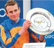  ?? Rex Features ?? Jockey Ryan Moore displays the 2,000 Guineas trophy after riding Churchill to victory at Newmarket, England yesterday. It was second success in the race after Gleneagles in 2015.