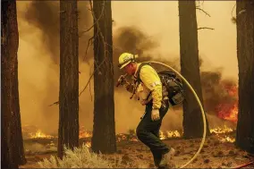  ?? AP PHOTO/NOAH BERGER ?? A firefighte­r battles the Caldor Fire along Highway 89, Tuesday, Aug. 31, 2021, near South Lake Tahoe, Calif.